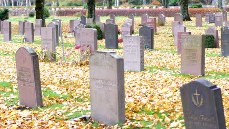 The-tombstones,-the-dried-leaves,-captured-at-a-graveyard-in-Kviberg,-Gothenburg,-Sweden---Focus-pull