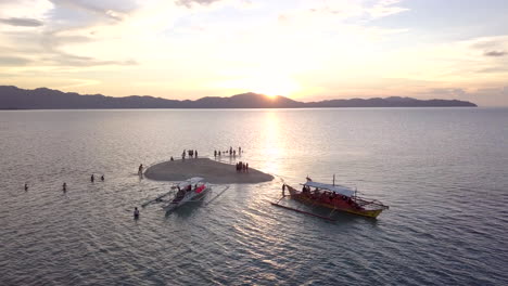 Luftaufnahme-Einer-Kleinen-Insel-Mit-Touristen,-Die-Den-Sonnenuntergang-Auf-Den-Philippinen,-Palawan-Genießen