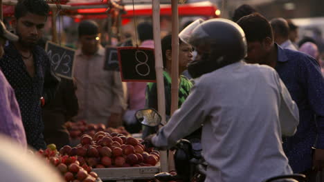 A-man-on-a-motorcycle-looks-at-some-peaches