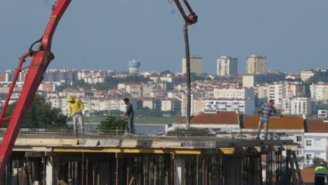 Group-of-workers-labour-on-rooftop,-construction-site-Building