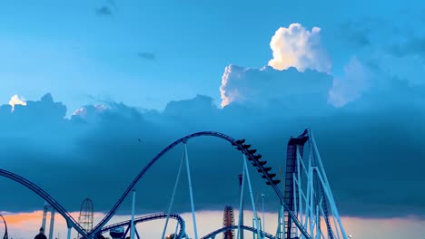 Dramatic-slow-motion-video-of-Gatekeeper-roller-coaster-with-cloudy-blue-sky-background-at-cedar-point-amusement-park-in-Sandusky,-Ohio,USA