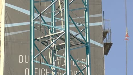 Close-Up-Shot-of-Building-Under-Construction-With-Crane-in-Foreground-in-Dublin,-Ireland-on-a-Sunny-Day