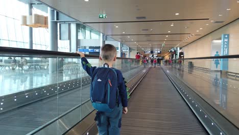 Helsinki,-Finlandia---Julio-De-2019:-Lindo-Niño-Caucásico-Con-Mochila-En-Una-Pasarela-Móvil-En-El-Vestíbulo-Del-Aeropuerto-De-Helsinki