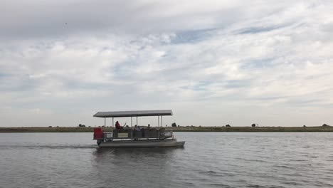 Un-Barco-Turístico-Medio-Vacío-Navega-Lentamente-Por-El-Río-Chobe-En-África