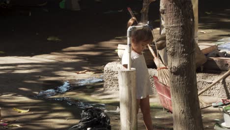 Small-Asian-child-in-a-rural-village-playing-at-a-well-in-Indonesia