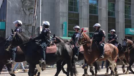 Toronto-Police-Service-Mounted-Unit-approaches-intersection-on-Horseback,-Toronto