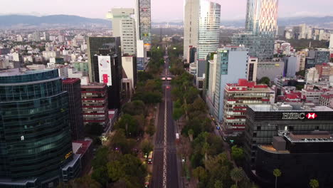 Toma-Aérea-De-Un-Amanecer-Entre-Los-Edificios-De-La-Avenida-Paseo-De-La-Reforma-Con-El-ángel-De-La-Independencia