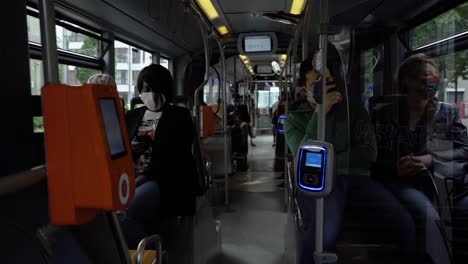 City-commuters-wearing-face-masks-on-bus-public-transport,-coronavirus