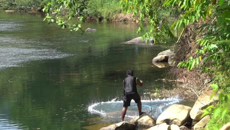 Ein-Thailändischer-Fischer-Wirft-Ein-Netz-In-Den-Fluss-Und-Versucht,-In-Zeitlupe-Fische-Zu-Fangen