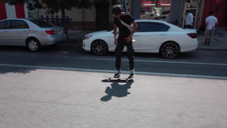 Un-Hombre-Adulto-Afroamericano-Patina-Alegremente-Y-Hace-Ollies-Por-Las-Calles-De-Nueva-York,-Nueva-York.