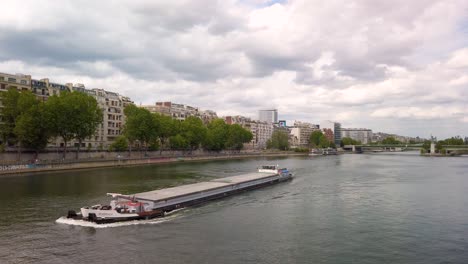 Romantic-Peniche-Parisian-boat-cruising-on-Seine-river-with-cloudy-sky