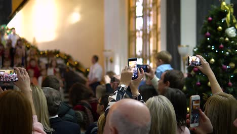 multiple-adult-people-with-mobile-phones-shooting-singing-children's-choir