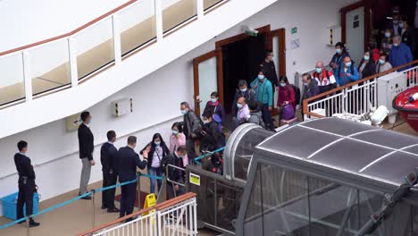 Los-Pasajeros-Hacen-Cola-Para-Desembarcar-Del-Crucero-World-Dream-En-La-Terminal-De-Cruceros-Kai-Tak-En-Hong-Kong-Después-De-Días-De-Cuarentena.