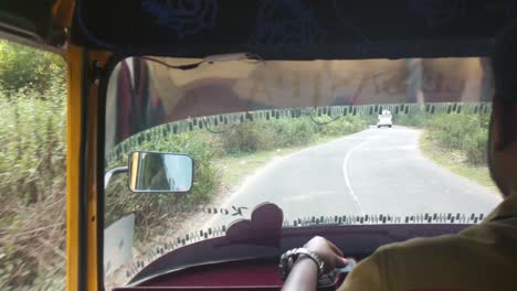 Passenger-POV-of-Tuk-Tuk-Driver-Driving-Through-Tea-Plantations-above-Munnar,-Kerala,-India