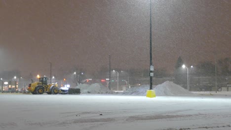 Cucharón-Cargador-De-Nieve-Frontal-Gigante-Montado-En-Una-Excavadora-Por-La-Noche-En-Una-Agradable-Nevada