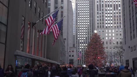 Árbol-De-Navidad-Del-Rockefeller-Center,-Lejos-En-ángulo-Medio-Con-Gente-Caminando,-Familias-Pasando-Tiempo-Juntas-Durante-La-Temporada-Navideña