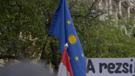 Bandera-De-La-UE-Ondeando-Con-El-Sol-Dorado-Kurdo-En-El-Centro,-Protesta-Contra-Erdogan