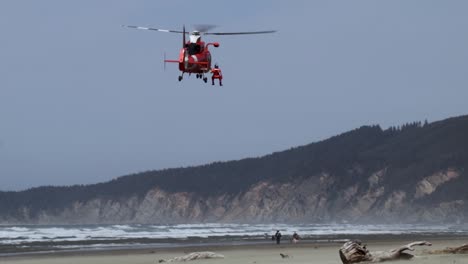 Coast-guard-helicoper-practicing-lifting-a-member-back-into-the-helicopter-while-in-flight