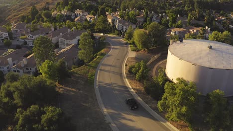 Filmische-Luftaufnahme-Eines-Schwarzen-Jeeps,-Der-Auf-Einer-Asphaltstraße-In-Den-Hügeln-Von-Los-Angeles-Fährt