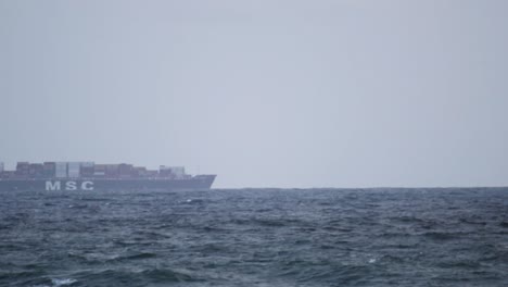 Loaded-Cargo-ship-in-Far-away-distance-horizon-moving-fast-barely-visible