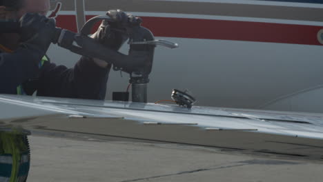 Ground-crew-worker-refuels-a-private-jet-airplane-on-the-tarmac