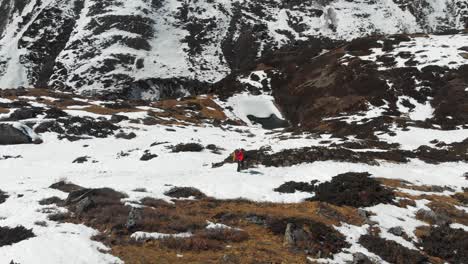 A-solo-trekker-trekking-through-a-snow-trail-in-a-sloppy-hill