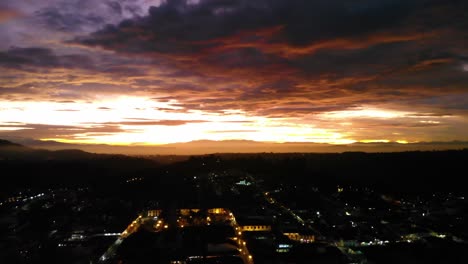 Insanely-bright-glowing-sunset-over-the-city-streets-in-Colombia,-aerial-4K