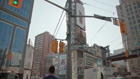 Walking-down-Dundas-street-on-a-busy,-sunny-day-in-Toronto,-Canada