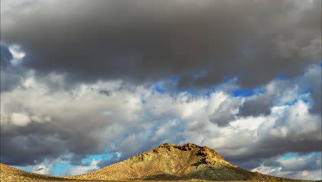 Wolken-Unterschiedlicher-Formen-Und-Größen-Ziehen-An-Einem-Strahlend-Sonnigen-Tag-über-Einen-Berg---Zeitraffer