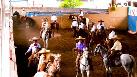 Charros,-Mexican-cowboys-performing-tricks-during-a-Charreada,-a-horse-rider-competition