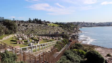 Waverley-Cemetery-located-near-Clovelly-Beach-with-people-walking-and-running-along-seaside-steps,-Handheld-stable-shot