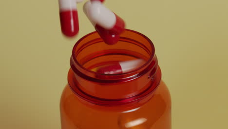 Slow-motion-high-angle-close-up-of-a-pill-bottle-as-pills-fall,-eventually-filling-the-bottle