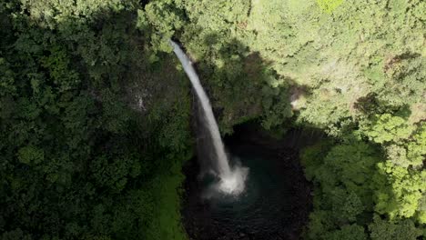 Beautiful-aerial-view-of-the-La-Fortuna-waterfall-in-Costa-Rica,-with-nature-all-around-it-and-popping-colors-everywhere