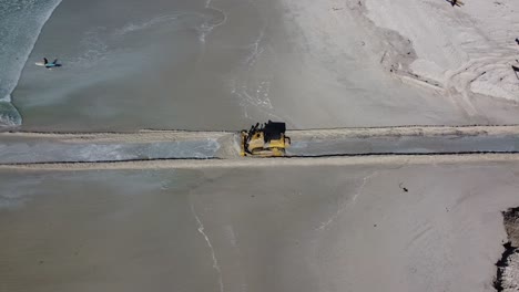 Una-Excavadora-De-Oruga-De-Maquinaria-Pesada-Abre-Un-Pasaje-Para-Que-El-Agua-Fluya-Desde-La-Reserva-Natural-Del-Estuario-De-Zandvlei-Hacia-La-Playa-De-Muizenberg