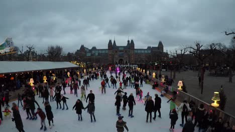 Timelapse-De-La-Ciudad-De-Amsterdam-Con-Gente-Patinando-Sobre-Hielo-Y-Turistas-Frente-A-La-Escritura-De-Amsterdam,-Países-Bajos