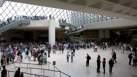 Medium-shot-of-the-large-indoor-square-under-the-pyramid-of-glass-in-the-Louvre-Museum,-Paris,-France