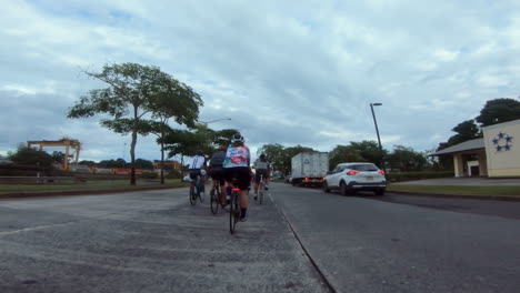 Un-Grupo-De-Ciclistas-Pedaleando-Por-La-Carretera-En-Una-Zona-Industrial.