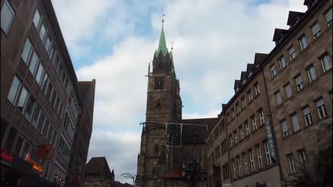 Walking-towards-the-historic-chruch-Lorenzkirche-in-Nuremberg-with-camera-tracking-of-the-two-high-towers-which-are-shining-in-the-sunlight