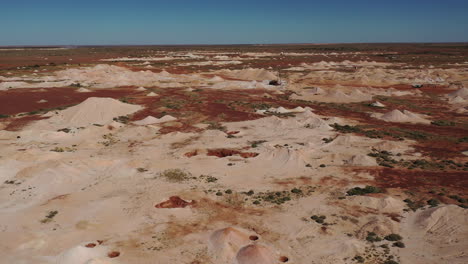 Aérea:-Disparo-De-Un-Dron-Sobrevolando-Las-Obras-Mineras-De-ópalo-Hacia-Grandes-Maquinarias-De-Perforación,-En-Coober-Pedy,-En-El-Interior-De-Australia-Meridional