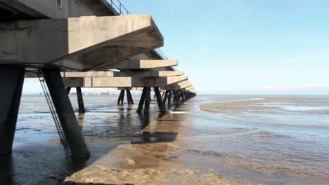 Volando-Bajo-Pilares-De-Hormigón-Del-Muelle-Petrolero-En-El-Mar-Del-Norte,-Wilhelmshaven,-Alemania