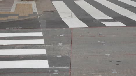 Heranzoomen-Auf-Den-Fuß-Von-Menschen-Mit-Blick-Auf-Die-Straße,-Die-Sich-Kreuzt.-Viele-Menschen-überqueren-Tagsüber-Die-Straße-Im-Stadtzentrum-Von-Tokio,-Japan-–-Kurzes-4K-UHD-Videofilmmaterial