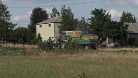 The-combine-harvester-and-tractor-with-a-trailer-filled-with-fresh-grain-leave-the-field