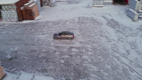 Toma-Aérea-De-Un-Automóvil-A-La-Deriva-En-Círculos-Sobre-La-Nieve