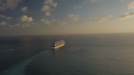 Aerial-overview-of-the-cruise-sailing-into-the-big-blue-ocean-with-blue-skies---slide-shot-4K