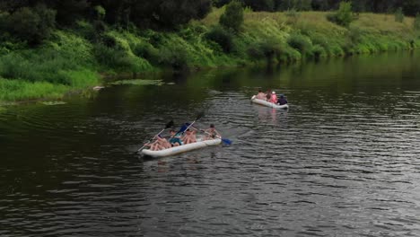 Luftaufnahme-Von-Zwei-Kanus-Mit-Jeweils-Vier-Personen,-Die-In-Der-Wildnis-Einen-Fluss-Hinunterpaddeln