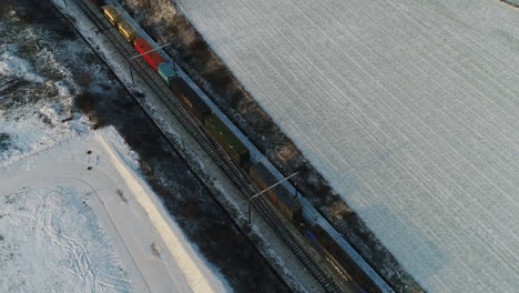 AERIAL:-A-freight-train-rides-through-a-snowy-landscape-at-low-speed