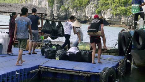 Bahía-De-Ha-Long,-Vietnam---Escena-Diferente-De-Turistas-Y-Lugareños-En-El-Sendero-Flotante-Que-Sirve-Como-Embarque-De-Mercancías-A-La-Isla---Plano-General