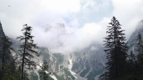 Berggipfel-In-Den-Dolomiten,-Bedeckt-Von-Wolken-Mit-Im-Wind-Schwankenden-Bäumen