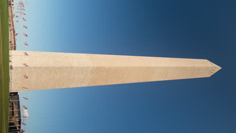 Washington-Monument-with-waving-American-flags-during-a-sunny-day-and-blue-sky