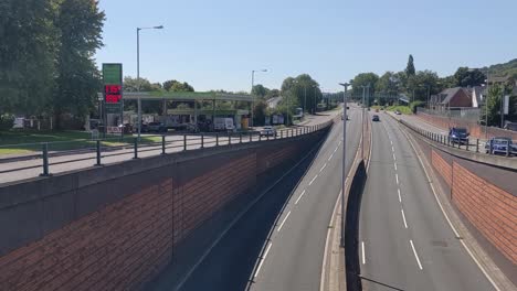 Panning-Shot-of-Steady-Traffic-on-Fast-Dual-Carriageway-with-Gas-Station-High-Petrol-Diesel-Prices-in-Swansea-UK-4K